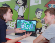 Zwei Jugendliche besprechen Computerspiel vor Laptop